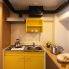 住戸内キッチン（キッチンカウンター利用時）<br />
限られた面積の中、キッチン拡張の要望に応えるため、可動式作業棚を廊下に設置する案で解決。